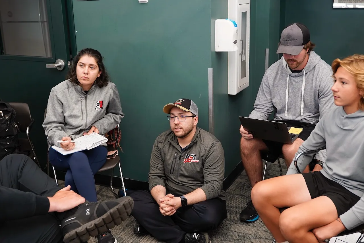 A group of people speak and take notes.
